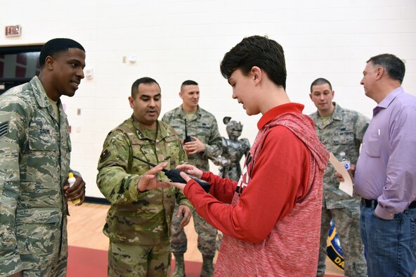 U.S. Air Force Staff Sgt. Dequanzel, 338th Training Squadron instructor, and Master Sgt. Gilbert Barrera, 338th TRS assistant flight chief, provides a land mobile radio demonstration to Brigand Mays, son of Bill Mays, 81st Training Wing wing inspection team lead, during Biloxi Science, Technology, Engineering and Mathematics Night at the Biloxi Jr. High School gymnasium, Biloxi, Mississippi, Feb. 12, 2019. The entire Biloxi school district was invited to the event which promoted STEM. Six career fields from Keesler's 81st Training Wing and the 81st Training Group participated in the event. (U.S. Air Force photo by Kemberly Groue)