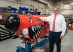 John Hutton, principal technical manager, Littoral and Mine Warfare Systems
at Naval Surface Warfare Center Panama City Division poses with an unmanned
underwater vehicle used for mine countermeasure testing.
