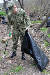 Seaman Carl Steele, who is waiting to attend Navy Medical corpsman classes, pitches in to help clean up trash and debris Feb. 16 at the ninth annual Joint Base San Antonio Basura Bash at Joint Base San Antonio-Fort Sam Houston’s Salado Creek Park.