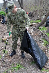 Seaman Carl Steele, who is waiting to attend Navy Medical corpsman classes, pitches in to help clean up trash and debris Feb. 16 at the ninth annual Joint Base San Antonio Basura Bash at Joint Base San Antonio-Fort Sam Houston’s Salado Creek Park.