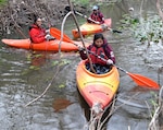 A trio of Air Force Airmen  make their way along Salado Creek in kayaks, helping clear out a year's worth of accumulated debris at the ninth annual Joint Base San Antonio Basura Bash Feb. 16 at Joint Base San Antonio-Fort Sam Houston’s Salado Creek Park.