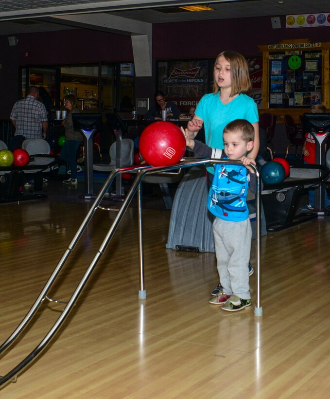 Maya, 10, assists her brother, Beckett, 5, during the Hearts Apart Bowling Extravaganza Feb. 16 at the Kirtland Bowling Center. 
Hearts Apart, a program run by Airman and Family Readiness to assist Team Kirtland families separated from loved ones due to deployment, holds family appreciation events throughout the year. (U.S. Air Force photo by Jim Fisher)
