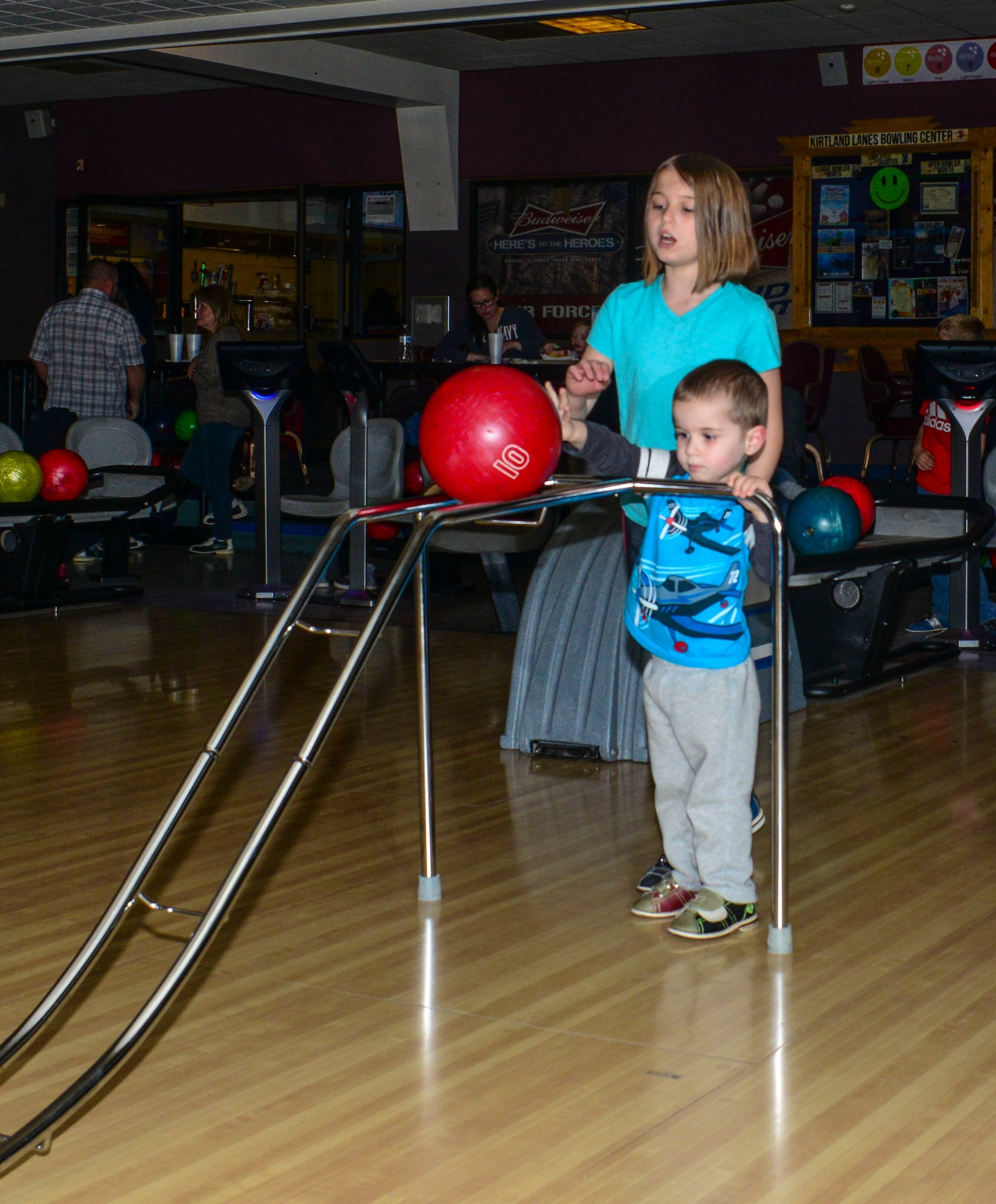 Maya, 10, assists her brother, Beckett, 5, during the Hearts Apart Bowling Extravaganza Feb. 16 at the Kirtland Bowling Center. 
Hearts Apart, a program run by Airman and Family Readiness to assist Team Kirtland families separated from loved ones due to deployment, holds family appreciation events throughout the year. (U.S. Air Force photo by Jim Fisher)