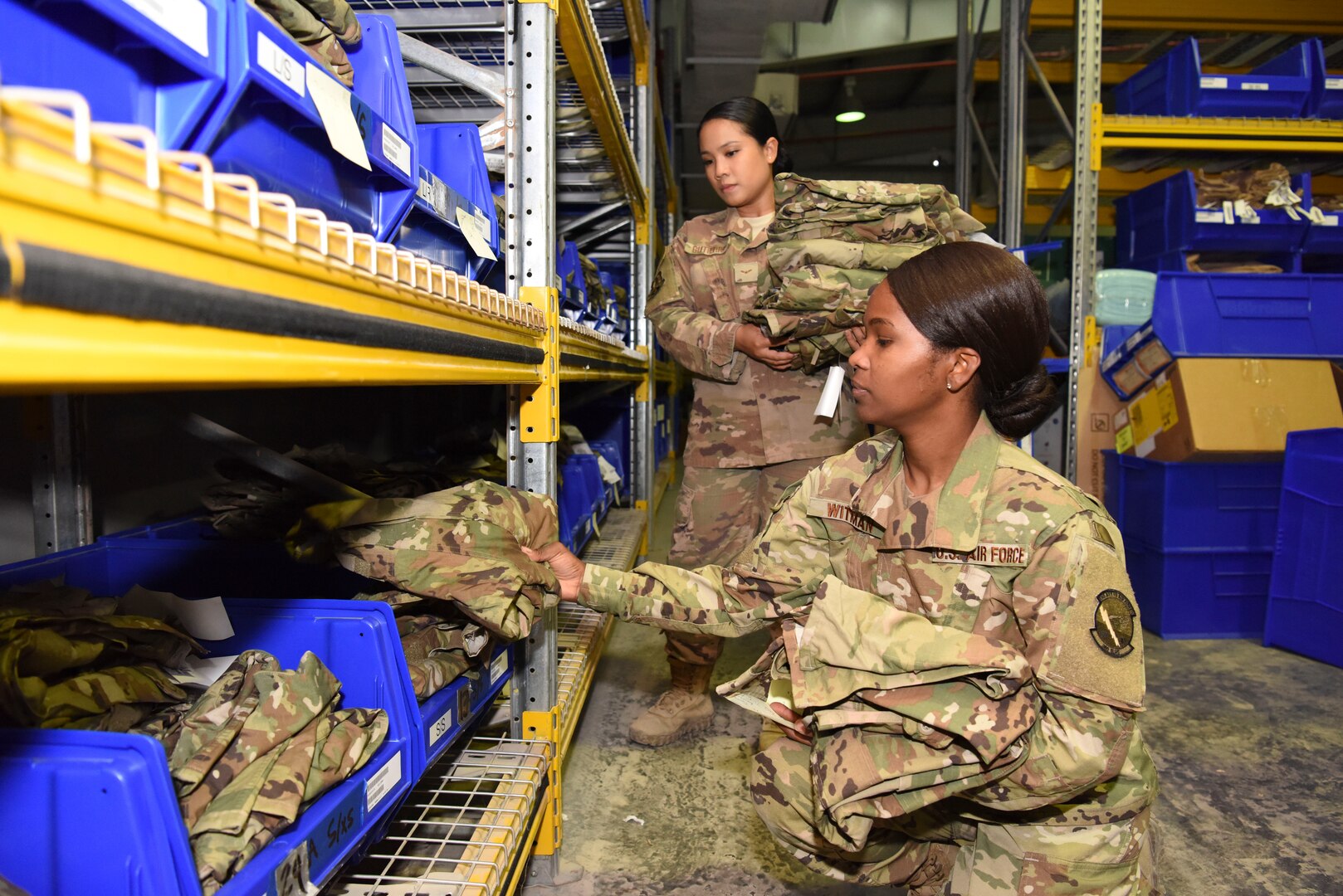 Senior Airman Kerby Witman, 380th ELRS customer service technician (front), and Airman 1st Class Michelle Gutierrez, 380th ELRS customer service technician, perform a uniform inspection inside of Desert Depot at Al Dhafra Air Base, United Arab Emirates, Feb. 11, 2019.