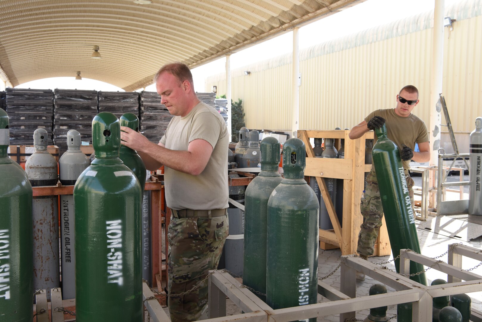 Staff Sgt. Tanner Collins, 380th Expeditionary Logistics Readiness Squadron inventory NCOIC, and Staff Sgt. Cody Sharkey, 380th ELRS hazardous materials section chief, store compressed cylinders at Al Dhafra Air Base, United Arab Emirates, Feb. 11, 2019.