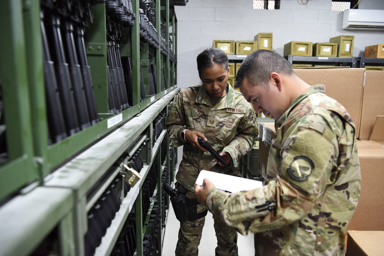 Tech. Sgt. Caresia Baldwin, 380th Expeditionary Logistics Readiness Squadron Individual Protective Equipment Section Chief, and Staff Sgt. Juan Nunez, 380th ELRS IPE supervisor, perform a weapons inventory inside the equipment accountability office at Al Dhafra Air Base, United Arab Emirates, Feb. 11, 2019.