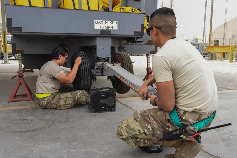 Airman 1st Class Mia Duran, 380th Expeditionary Maintenance Squadron Aerospace Ground Equipment technician, replaces a tire on the TLD air conditioning unit while Senior Airman Andyhoang Vu, 380th EMXS AGE technician, holds it in place, Feb. 11, 2019, at Al Dhafra Air Base, United Arab Emirates.