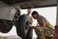 Airman 1st Class Sarah Derringer, 380th Expeditionary Maintenance Squadron Aerospace Ground Equipment technician, holds a tire in place while Airman 1st Class Mia Duran, 380th Maintenance Squadron Aerospace Ground Equipment technician, fastens the tire’s bolts Feb. 11, 2019, at Al Dhafra Air Base, United Arab Emirates.