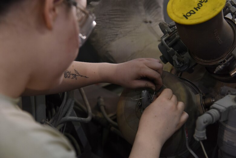 Airman 1st Class Sarah Derringer, 380th Expeditionary Maintenance Squadron Aerospace Ground Equipment technician, applies safety wire to the combustion can of a Dash 60 generator, Feb. 11, 2019, at Al Dhafra Air Base, United Arab Emirates.