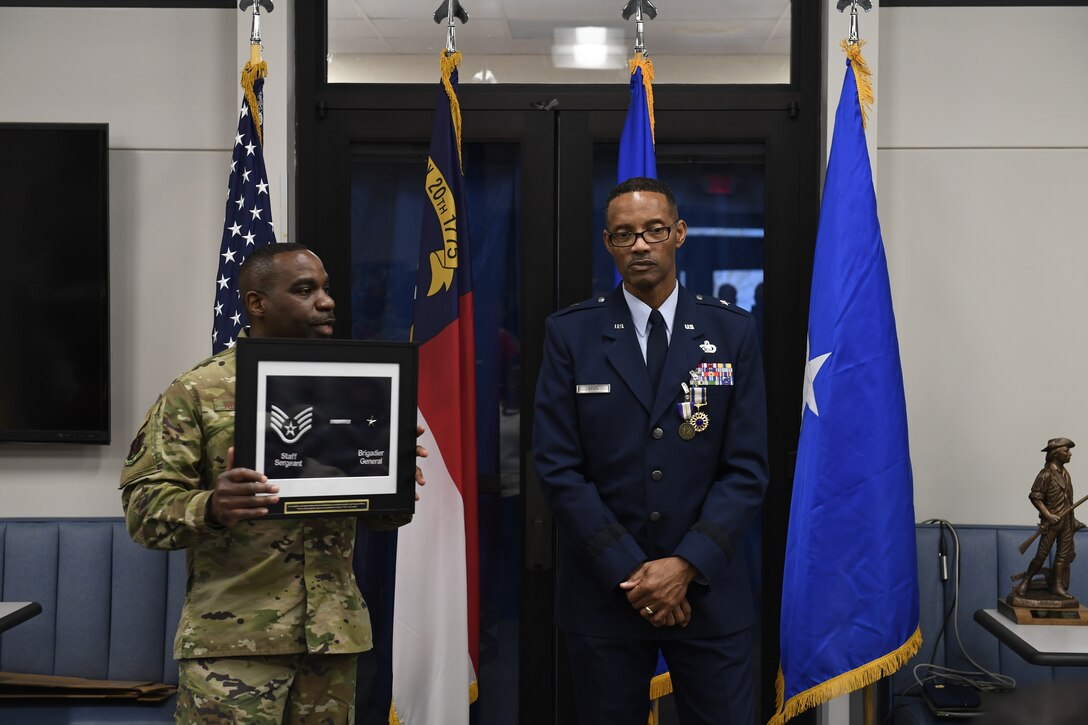 U.S. Air Force Chief Master Sgt. Maurice L. Williams, Senior Enlisted Leader for the Kansas National Guard, holds a plaque showing Brig. Gen. Clarence Ervin’s highest rank as an enlisted member and as a general officer during the retirement reception at the North Carolina Air National Guard Base (NCANG), Charlotte Douglas International Airport, Feb. 09, 2019. Family, friends and guard members gathered to celebrate the retirement of Gen. Ervin, Chief of Staff for the NCANG, after serving in the military for 37 years.