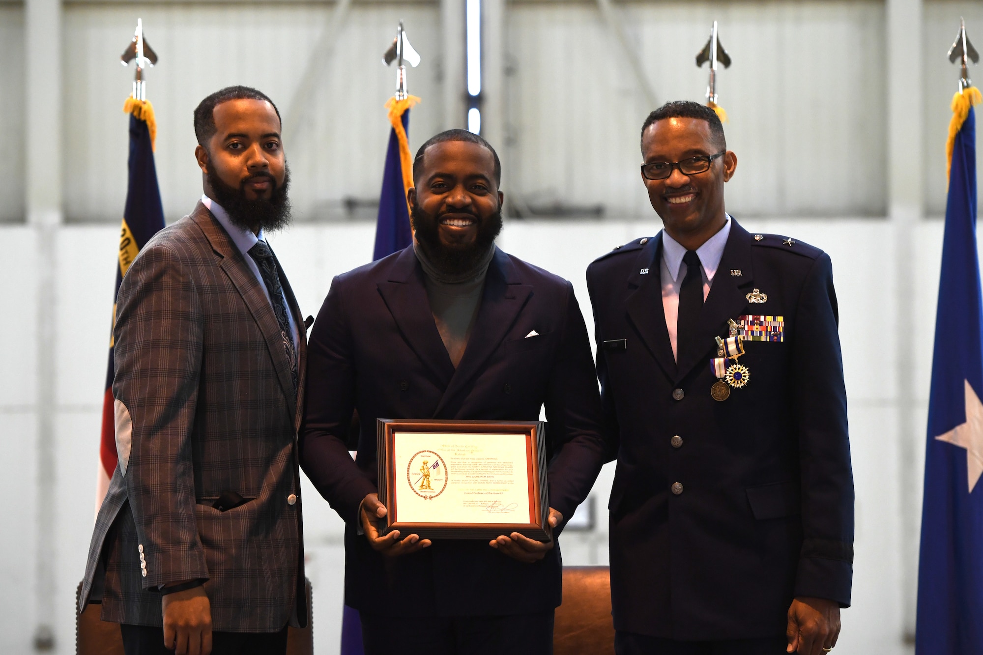 U.S. Air Force Brig. Gen. Clarence Ervin (right) and his two sons, CJ (left) and Chris (center), accept an award on behalf of their late mother and Gen. Ervin’s late wife during his retirement ceremony at the North Carolina Air National Guard Base (NCANG), Charlotte Douglas International Airport, Feb. 09, 2019. Family, friends and guard members gathered to celebrate the retirement of Gen. Ervin, Chief of Staff for the NCANG, after serving in the military for 37 years.