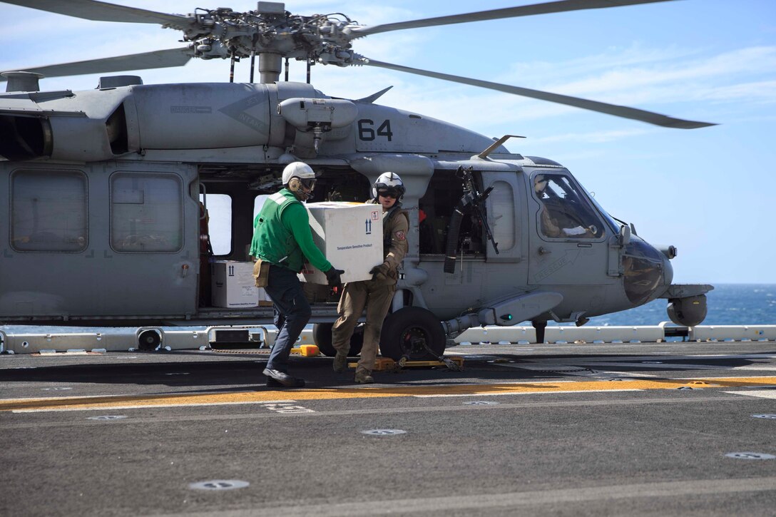 U.S. Navy Sailors help offload freight from an MH-60S Seahawk on the flight deck of the Wasp-class amphibious assault ship USS Kearsarge. Aircraft routinely transport 22nd Marine Expeditionary Unit personnel, mail and cargo to the Kearsarge. Marines and Sailors with the 22nd MEU and Kearsarge Amphibious Ready Group are deployed to the 5th Fleet area of operations in support of naval operations to ensure maritime stability and security in the Central Region, connecting the Mediterranean and the Pacific through the western Indian Ocean and three strategic choke points. (U.S. Marine Corps photo by Lance Cpl. Tawanya Norwood)