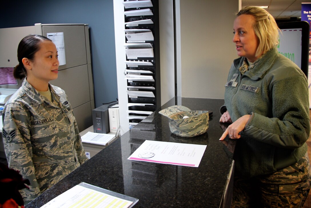 U.S. Air Force reservist and Citizen Airman, Senior Airman Kathryn Baskerville, 932nd Airlift Wing, Force Support Squadron customer support technician, listens to a question from 932nd Recruiting Squadron recruiter Tech. Sgt. Sara Seibel.  Sergeant Seibel stopped by Feb. 9, 2019, at Scott Air Force Base, Illinois, to visit the wing she has helped recruit for several years.  The front desk at the 932nd Airlift Wing headquarters building helps both wing members and active duty with identification cards and other FSS issues and questions.  For more information on joining the Air Force Reserve Command, those interested can contact Air Force Reserve recruiting at 1-800-257-1212 or (618)-781-1185.  (U.S. Air Force photo by Lt. Col. Stan Paregien)