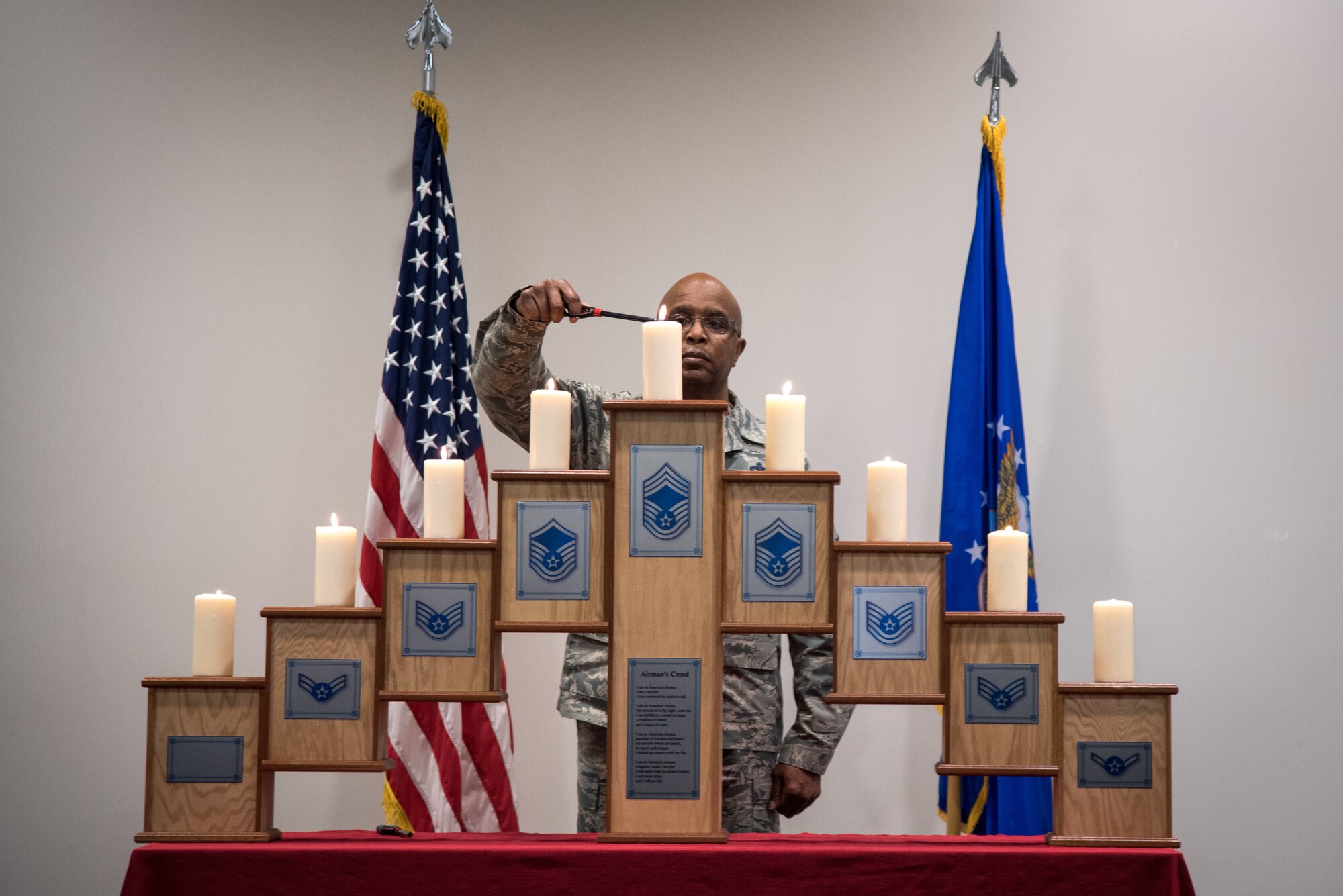 Chief Master Sgt. Marshall Harris, 403rd Maintenance Group quality assurance chief, lights the final ceremonial candle during the Noncommissioned Officer and Senior Noncommissioned Officer Induction Ceremony at Keesler Air Force Base, Mississippi February 10, 2019.  This induction ceremony recognizes Airmen rising in the ranks and the responsibilities of these new leaders and mentors in the U.S. Air Force Reserve. (U.S. Air Force photo by Staff Sgt. Shelton Sherrill)