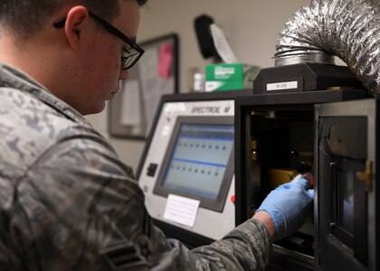 U.S. Air Force Airman 1st Class Jacob Boer, 1st Maintenance Squadron non-destructive inspection journeyman, loads oil into a SpectrOil M machine at Joint Base Langley-Eustis, Virginia, Feb. 15, 2019.