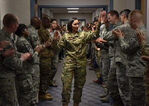 Uniformed member greeting other military members  with hi-fives in building