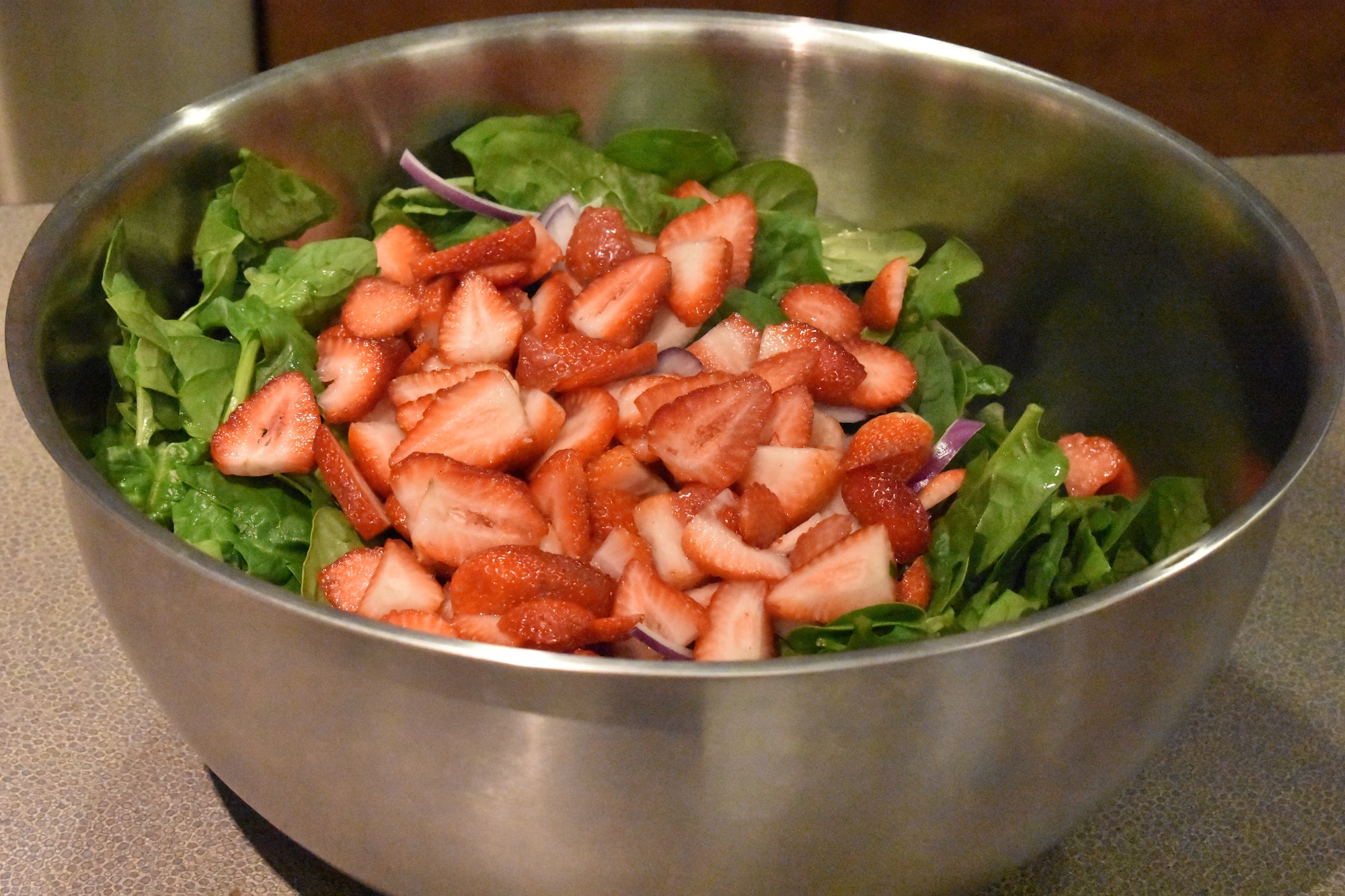 Strawberries rest atop a bed of salad greens Feb. 13, 2019, at Dover Air Force Base, Del. During the Dorm to Gourm class, Airmen prepared several dishes, including a salad and an Italian entree. (U.S. Air Force photo by 2nd Lt. Lorraine Cho)