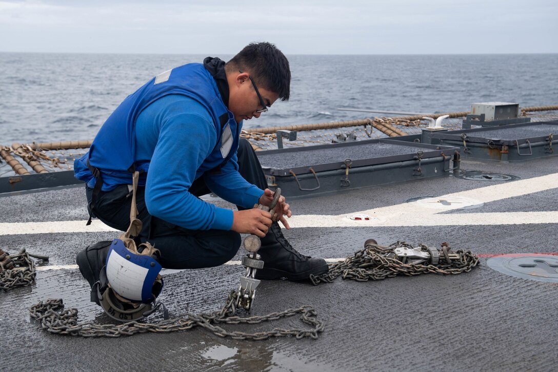 A service member prepares a flight deck for operations.