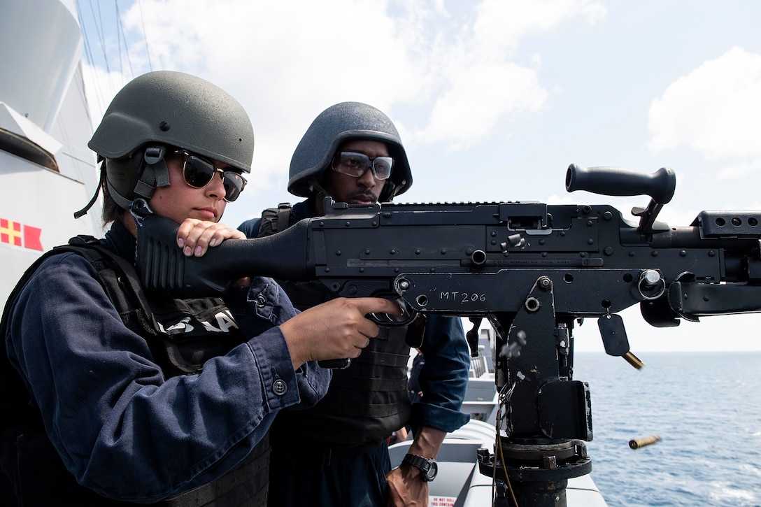 A service member fires a gun.