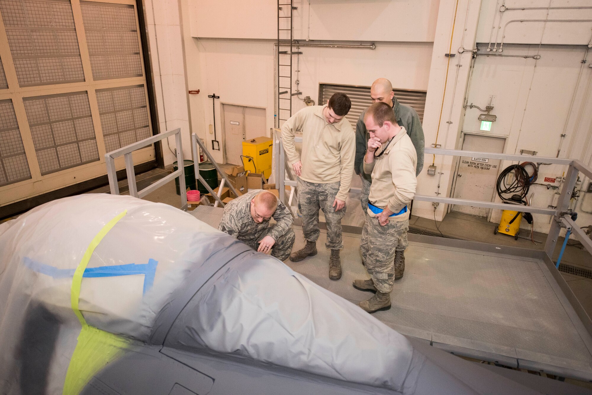 U.S. Air Force Airmen with the 35th Maintenance Squadron review the assignments and details of the F-16 Fighting Falcon repaint at Misawa Air Base, Japan, Jan. 29, 2019. The Airmen discussed the body of the aircraft to cover what procedures needed to be completed in order to maintain efficiency in refurbishing the jet. (U.S. Air Force photo by 1st Lt. Jeremy Garcia)