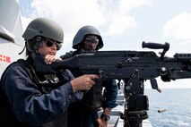 A service member fires a gun.