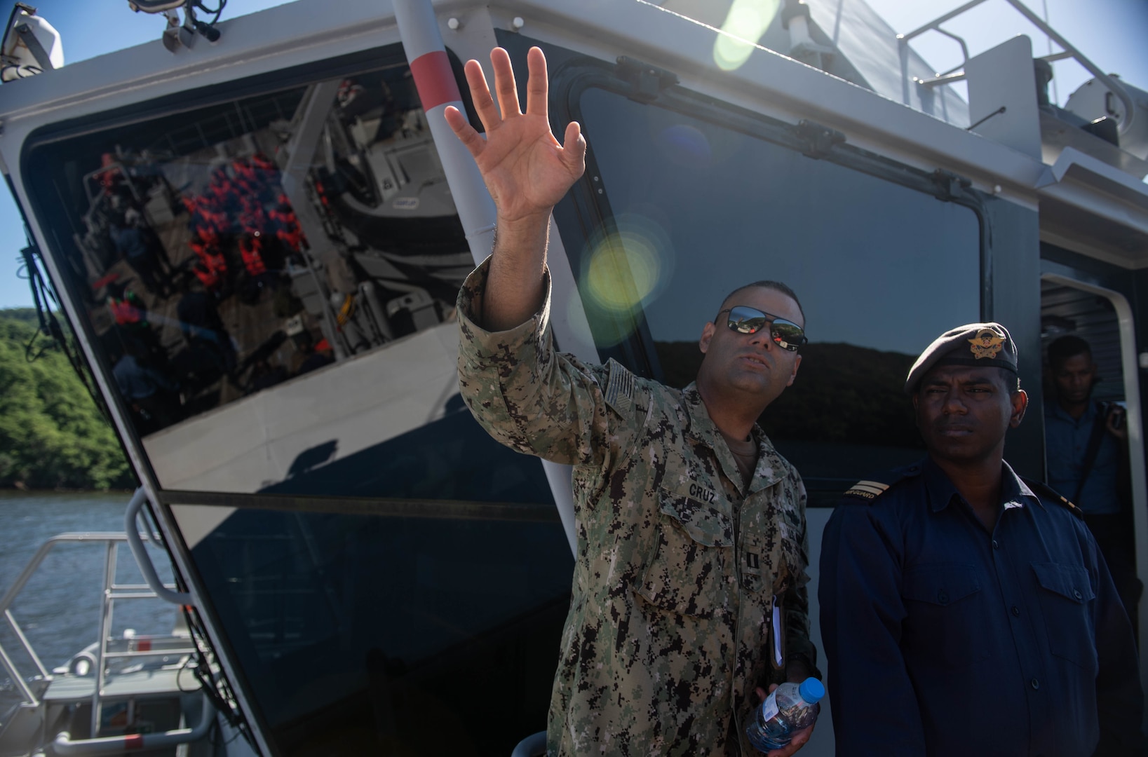 U.S. Navy Lt. David Cruz, Southern Partnership Station 2018’s Fleet Health Engagement Team (FHET) officer-in-charge, speaks with a Trinidad and Tobago (TTO) military professional as part of functional exercise Red Fish aboard a TTO coast guard vessel during Southern Partnership Station 2018.