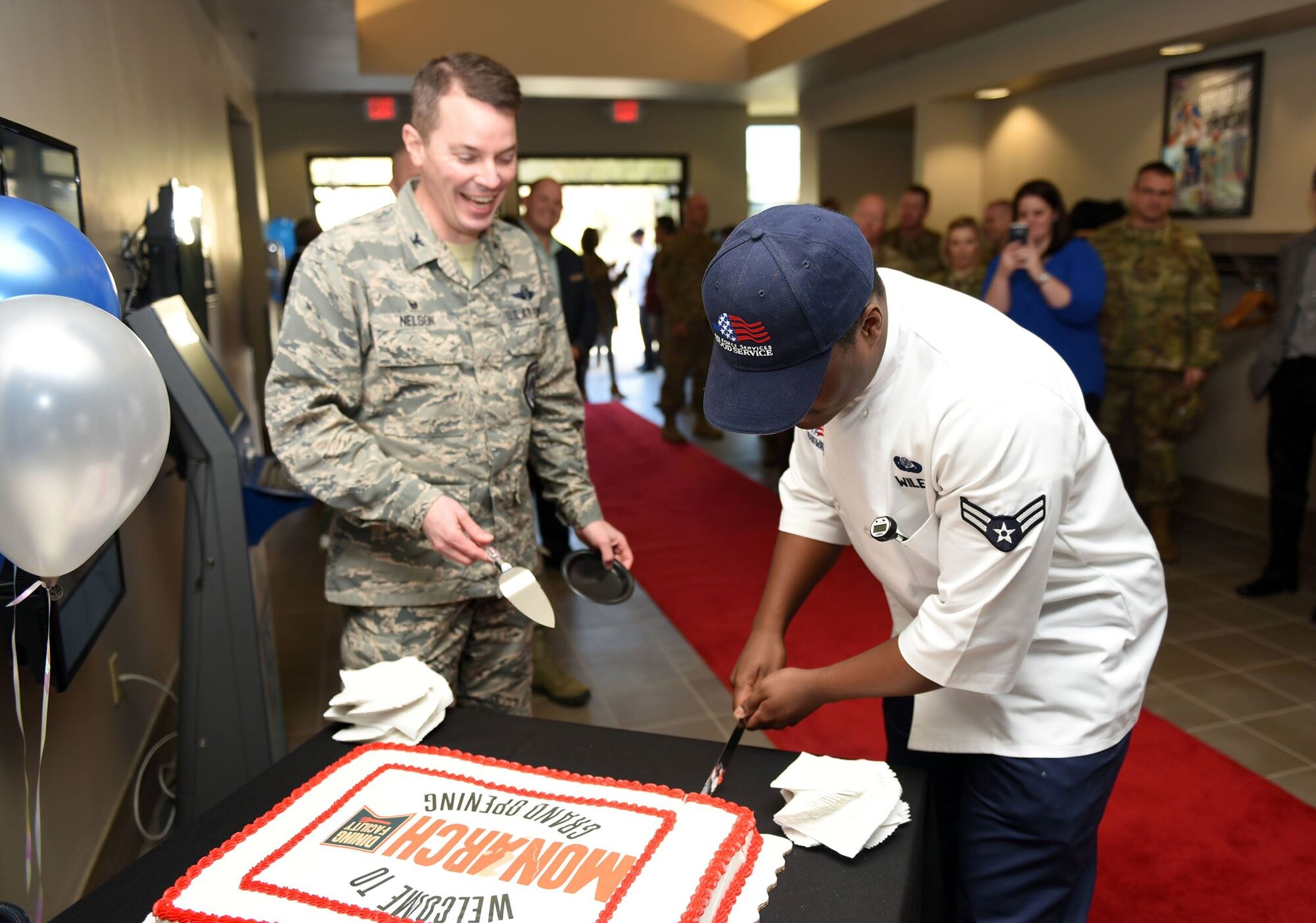 Col. Jeffrey Nelson, 60th Air Mobility Wing commander, and Airman 1st Class Keith Wiley, 60th Force Support Squadron food service apprentice, cut a cake made in celebration of Travis Air Force Base's reopening of its base dining facility. Throughout the reconstruction and renovation of the dining facility, the 60th FSS had been serving Airmen from a side room in the base's Delta Breeze Club. (U.S. Air Force photo by Airman 1st Class Christian Conrad)