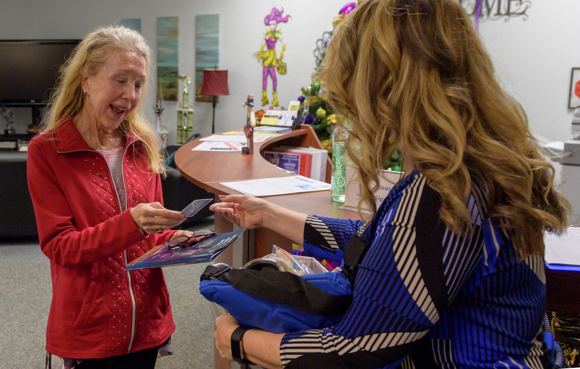 Holly Fisher, 81st Force Support Squadron Airman & Family Readiness Center community readiness specialist, presents Mary Buckley, daughter of U.S. Air Force Capt. Robert Gereer, with her Gold Star Family Member ID card inside the Sablich Center at Keesler Air Force Base, Mississippi, Feb. 15, 2019. Gereer served during the Korean War and was placed in a missing in action (MIA) status due to his remains not being found. As a surviving daughter of an MIA service member, Buckley is allowed to obtain an ID card for recognition and installation access so that she can attend events and access A&FRC referral services. (U.S. Air Force photo by Andre' Askew)