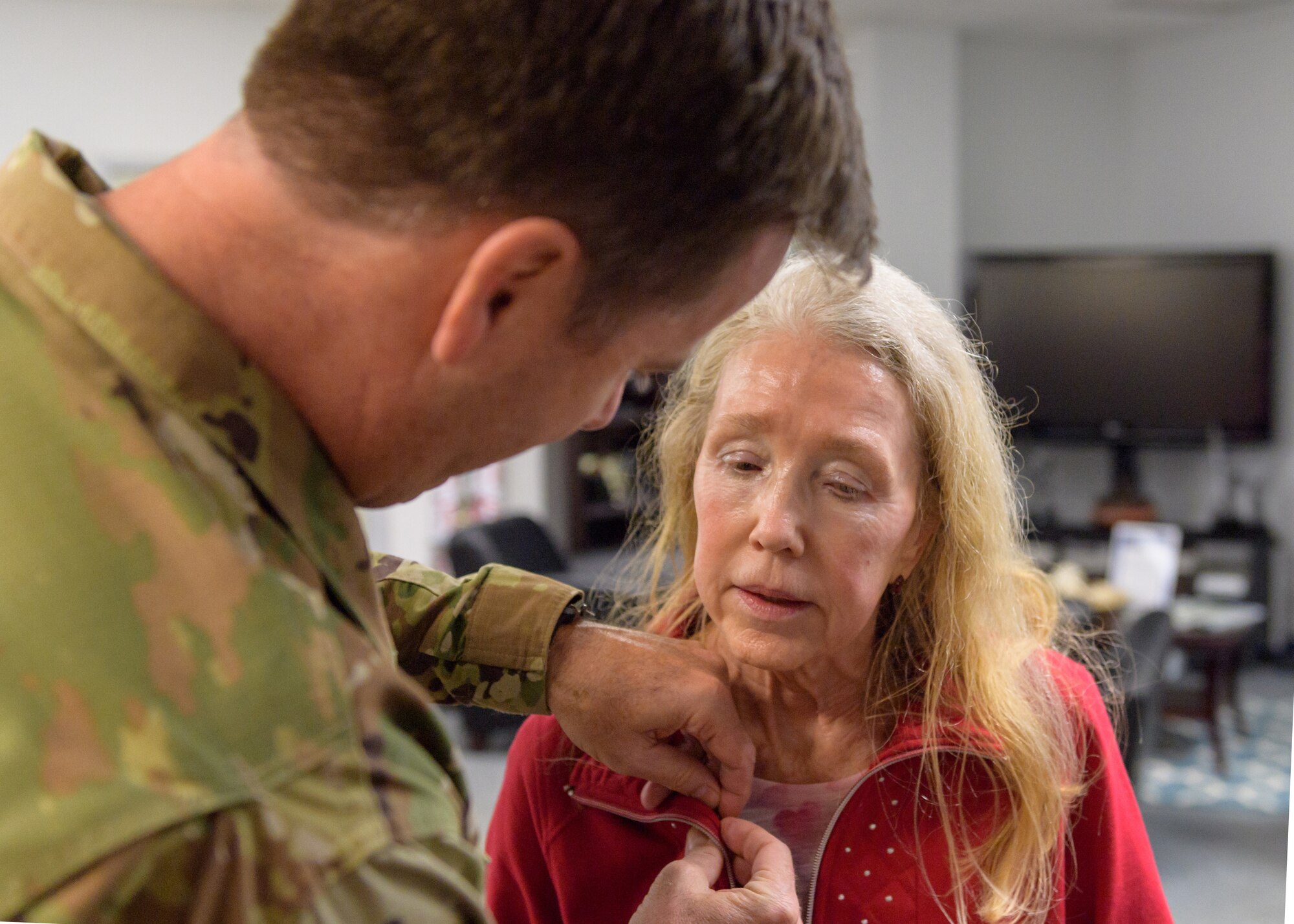 U.S. Air Force Col. Lance Burnett, 81st Training Wing vice commander, pins a Gold Star Family Member lapel pin on the collar of Mary Buckley, daughter of U.S. Air Force Capt. Robert Gereer, inside the Sablich Center at Keesler Air Force Base, Mississippi, Feb. 15, 2019. Gereer served during the Korean War and was placed in a missing in action (MIA) status due to his remains not being found. As a surviving daughter of an MIA service member, Buckley is allowed to obtain an ID card for recognition and installation access so that she can attend events and access A&FRC referral services. (U.S. Air Force photo by Andre' Askew)