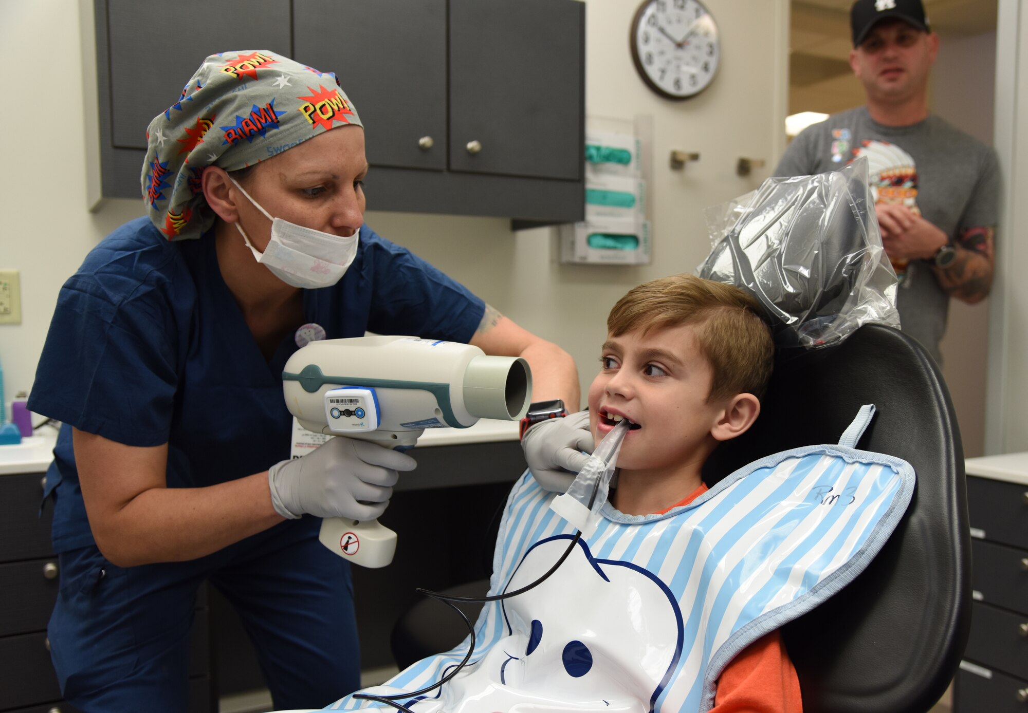 Regina Yarbrough, 81st Dental Squadron dental technician, conducts an X-ray exam on Raylan Wanhala, son of U.S. Air Force Tech. Sgt. Daniel Wanhala, 81st Security Forces Squadron flight chief, as his dad stands by during the 9th Annual Give Kids a Smile Day at the dental clinic inside the Keesler Medical Center at Keesler Air Force Base, Mississippi, Feb. 15, 2019. The event was held in recognition of National Children's Dental Health Month and included free dental exams, radiographs and cleanings for children age two and older. (U.S. Air Force photo by Kemberly Groue)