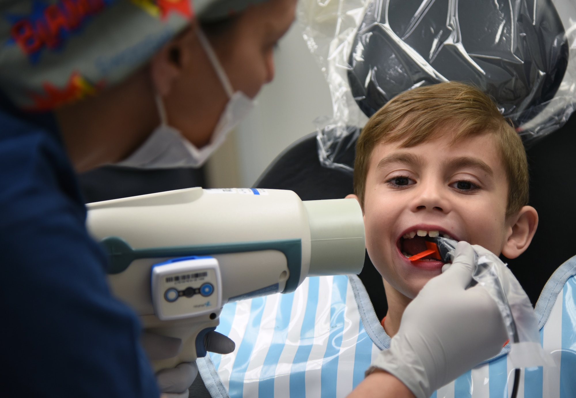 Regina Yarbrough, 81st Dental Squadron dental technician, conducts an X-ray exam on Raylan Wanhala, son of U.S. Air Force Tech. Sgt. Daniel Wanhala, 81st Security Forces Squadron flight chief, during the 9th Annual Give Kids a Smile Day at the dental clinic inside the Keesler Medical Center at Keesler Air Force Base, Mississippi, Feb. 15, 2019. The event was held in recognition of National Children's Dental Health Month and included free dental exams, radiographs and cleanings for children age two and older. (U.S. Air Force photo by Kemberly Groue)
