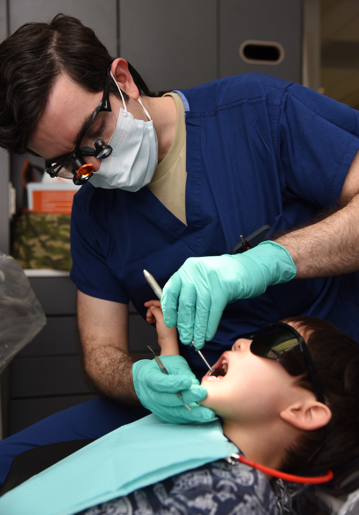 U.S. Air Force Capt. (Dr.) Stephan Javaheri, 81st Dental Squadron general dentist, conducts a dental exam on William Blankenship, II, son of Master Sgt. William Blankenship, 81st Training Support Squadron qualification training developer, during the 9th Annual Give Kids a Smile Day at the dental clinic inside the Keesler Medical Center at Keesler Air Force Base, Mississippi, Feb. 15, 2019. The event was held in recognition of National Children's Dental Health Month and included free dental exams, radiographs and cleanings for children age two and older. (U.S. Air Force photo by Kemberly Groue)