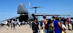 Spectators walk to a 433rd Airlift Wing’s C-5M Super Galaxy from Joint Base San Antonio-Lackland while an A-10C Thunderbolt II performs during the Washington’s Birthday Celebration Association Stars and Stripes Air Show Spectacular at the Laredo International Airport in Laredo, Texas Feb. 17. The A-10 belongs to the A-10C Thunderbolt II Demonstration Team from Davis-Monthan Air Force Base, Arizona.