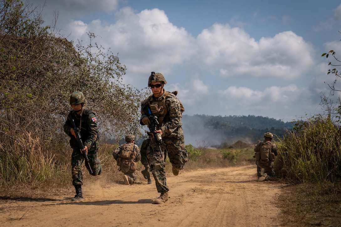 A  U.S. and Thai Marine run down a dirt road during a training exercise.