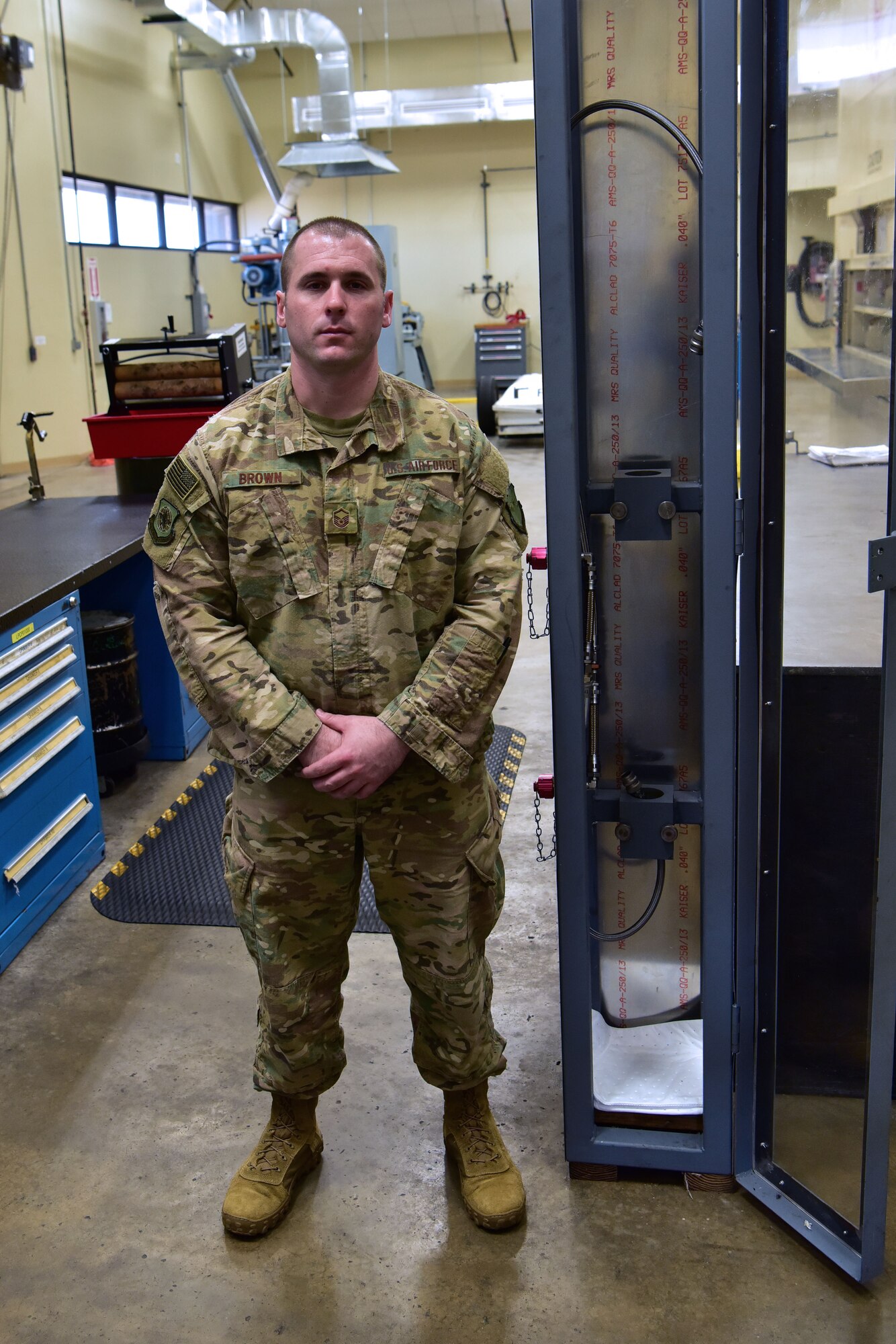 Airman stands next to his safety fixture.