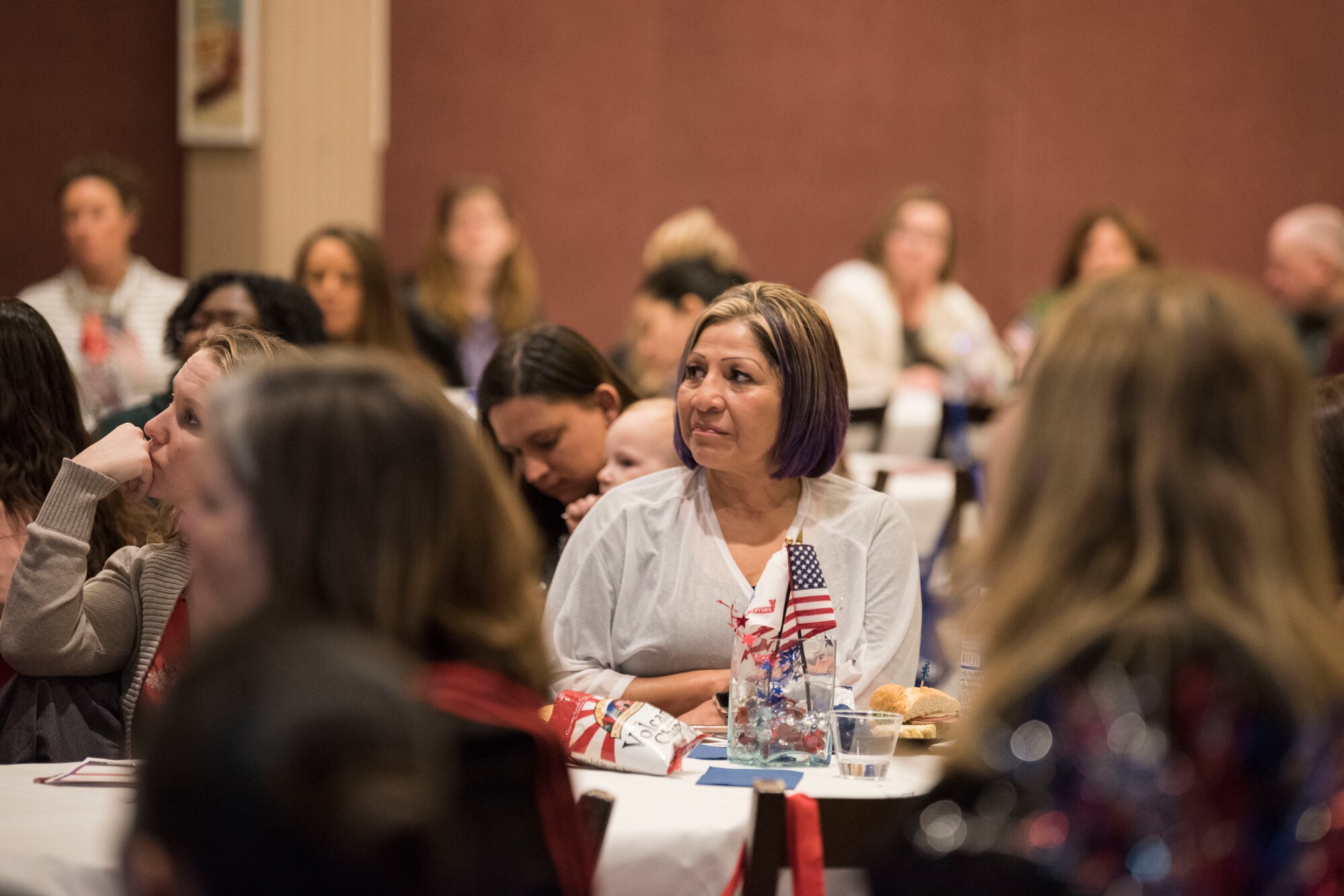 Attendees listen as Kristen Christy, the 2018 Air Force key spouse of the year, speaks to spouses during a military spouse town hall and luncheon at Joint Base Elmendorf-Richardson, Alaska, Feb. 12, 2019. The Military and Family Readiness Center-hosted event had more than 120 attendees with the theme “Taking Care of People.”