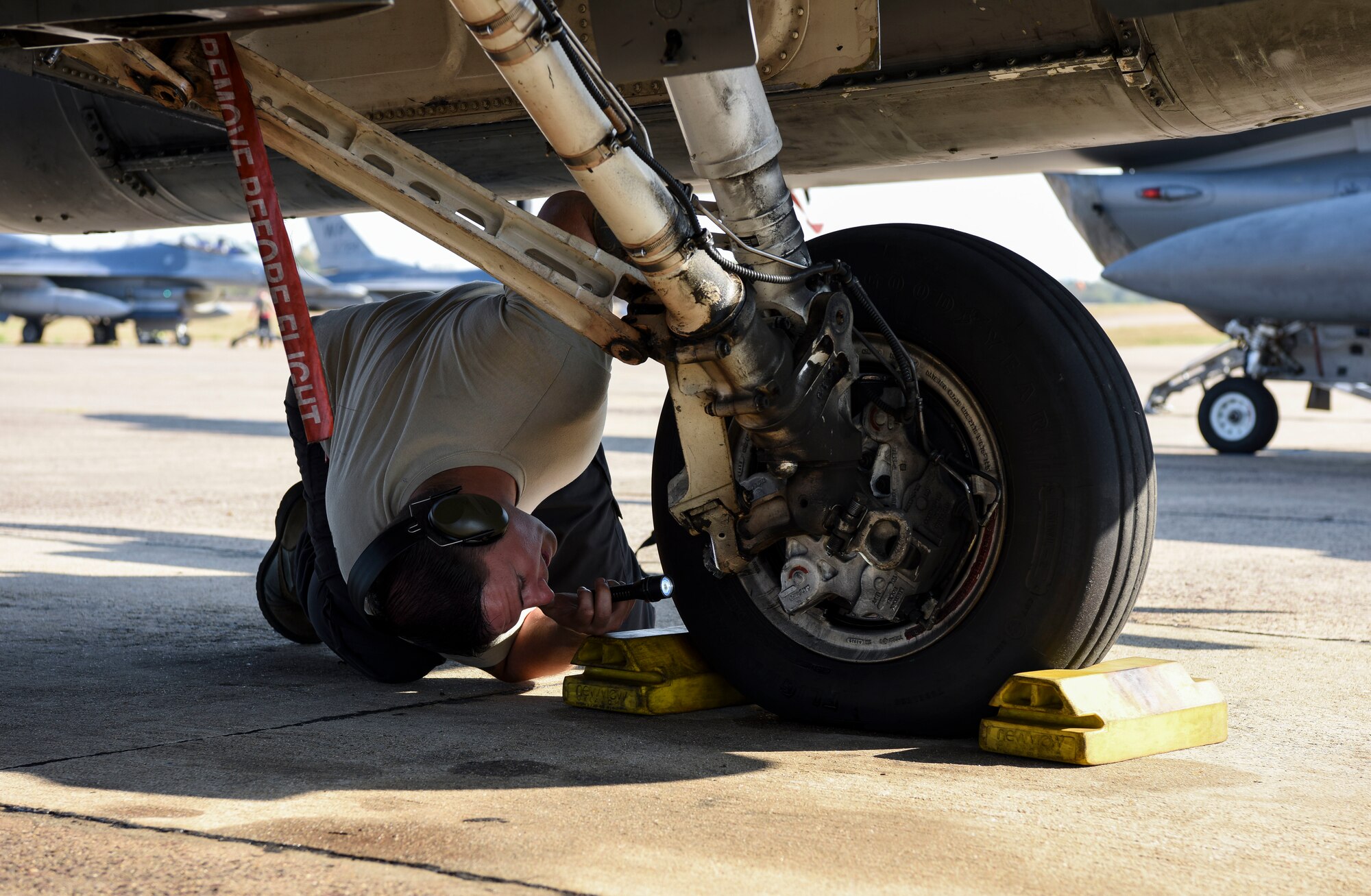 U.S. Air Force Staff Sgt. Travis Davis, 8th Aircraft Maintenance Squadron crew chief, inspects a USAF F-16 Fighting Falcon brake during Exercise Cobra Gold 2019 at Korat Royal Thai Air Force Base, Thailand, Feb. 19, 2019. Cobra Gold provides a venue for both U.S. and partner nations to advance interoperability and increase partner capacity in planning and executing complex and realistic multinational force and combined task force operations. (U.S. Air Force photo by Senior Airman Savannah L. Waters)