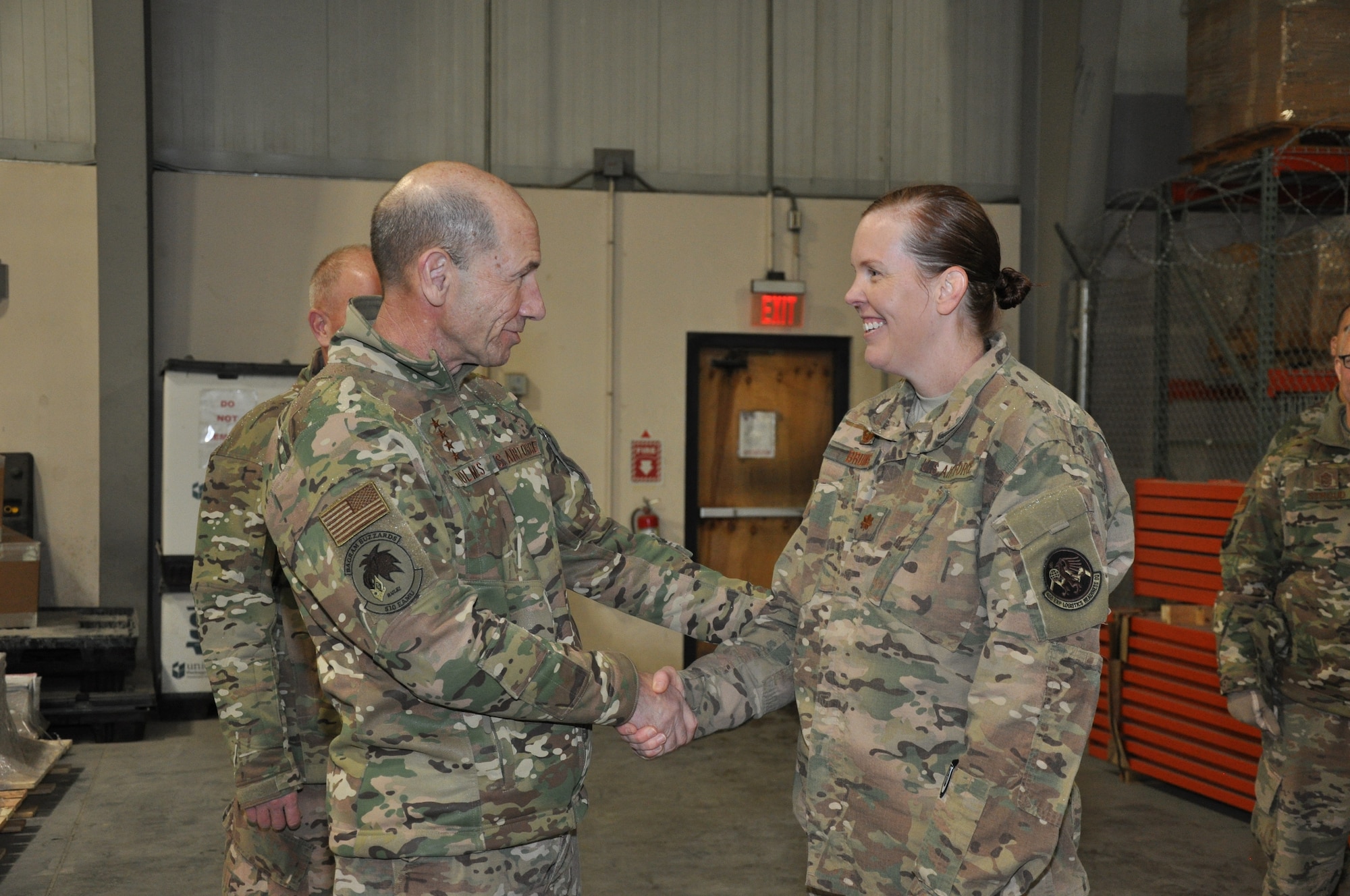 Gen. Mike Holmes, commander of Air Combat Command, coins Maj. Mieke Bruins, commander, 455th Expeditionary Logistics Readiness Squadron, during a visit to Bagram Airfield, Afghanistan, Feb. 13, 2019.