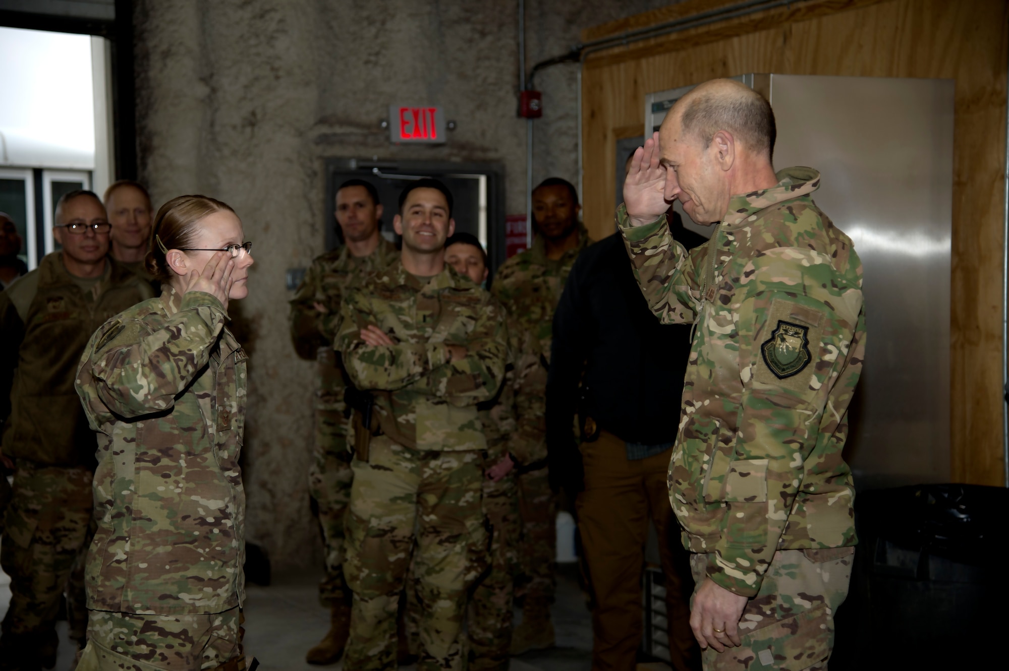 An Airman from the 455th Expeditionary Communications Squadron salutes Gen. Mike Holmes, commander of Air Combat Command,  after receiving his coin for excellence at Bagram Airfield, Afghanistan, Feb. 12, 2019.