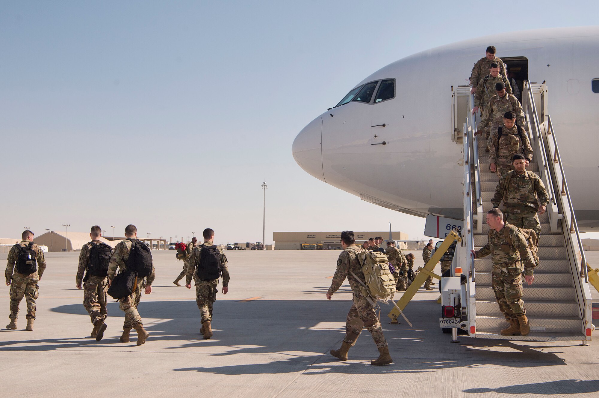 Deployed servicemembers take direction from 8th Expeditionary Air Mobility Squadron (EAMS) Airmen after their arrival at Al Udeid Air Base, Qatar, Feb. 20, 2019. 8th EAMS Airmen ensure aircraft can rapidly and safely deliver vital equipment and passengers to locations across U.S. Central Command’s area of responsibility. The squadron consists of active-duty, Air Force Reserve, and Air National Guard Airmen, who bring a diverse total force perspective to their mission. (U.S. Air Force photo by Tech. Sgt. Christopher Hubenthal)