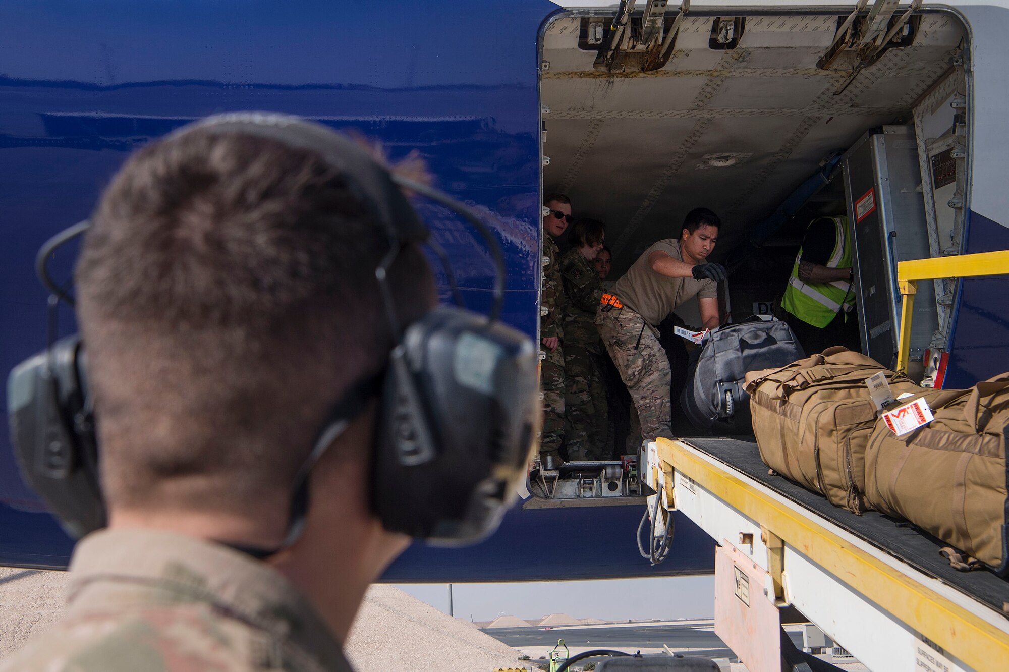 Staff Sgt. Gilbert Tumaneng, 8th Expeditionary Air Mobility Squadron (EAMS) passenger services supervisor, moves baggage onto a conveyer belt Feb. 20, 2019, at Al Udeid Air Base, Qatar. 8th EAMS Airmen ensure aircraft can rapidly and safely deliver vital equipment and passengers to locations across U.S. Central Command’s area of responsibility. The squadron consists of active-duty, Air Force Reserve, and Air National Guard Airmen, who bring a diverse total force perspective to their mission. (U.S. Air Force photo by Tech. Sgt. Christopher Hubenthal)