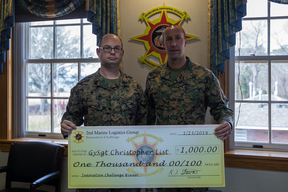 U.S. Marine Corps Gunnery Sgt. Christopher List, left, a maintenance chief with 2nd Transportation Support Battalion, receives a $1,000 check from Brig. Gen. Kevin J. Stewart, commanding general of 2nd Marine Logistics Group, for winning the 2nd MLG Innovation Challenge at Camp Lejeune, North Carolina, Feb. 15, 2019. The purpose of the innovation challenge is to solicit ground-breaking ideas to influence the future of the Marine Corps. (U.S. Marine Corps photo by Cpl. Ashley Lawson)