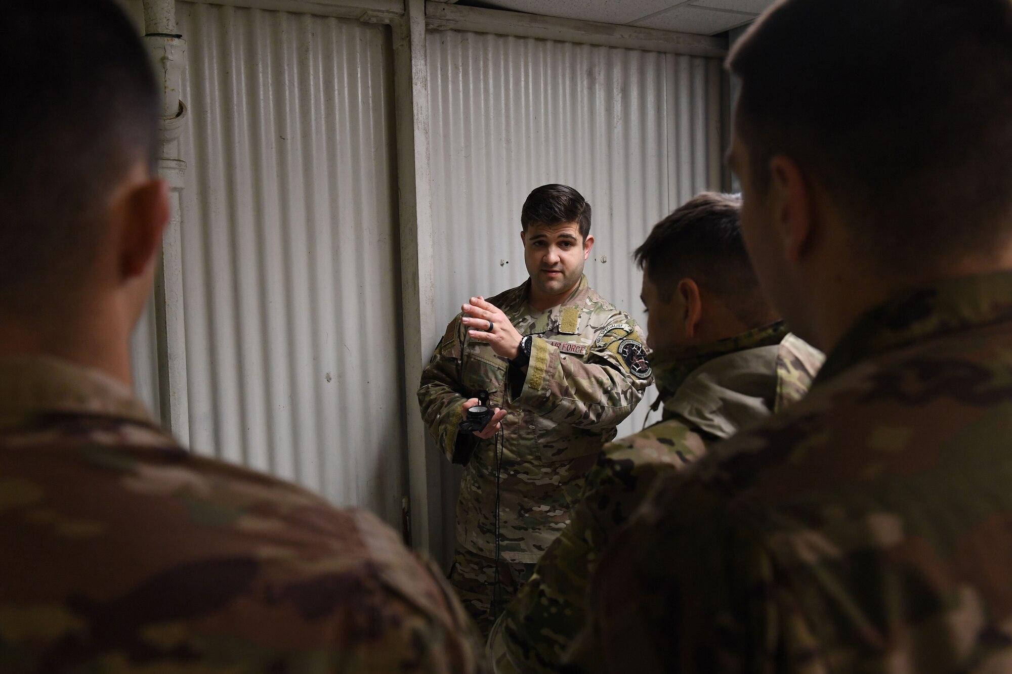 A man looks a group and points to the left of the image.