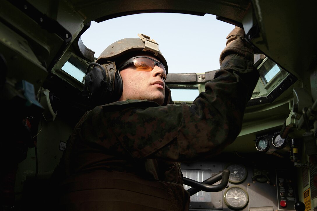 A Marine looks out of a vehicle.