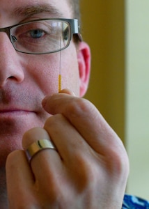 Lt. Cmdr. Jacques Bouchard, Naval Health Clinic Charleston staff physician, holds up an acupuncture needle at NHCC in Goose Creek, S.C.