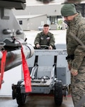 1st Lt. Wesley Kilmain ( left), an F-16 Fighting Falcon student pilot, drives a MJ-1 lift truck as Tech. Sgt. Brian Green, 149th Fighter Wing load standardization crewmember, observes weapons loading during training at Joint Base San Antonio-Lackland Feb. 9.