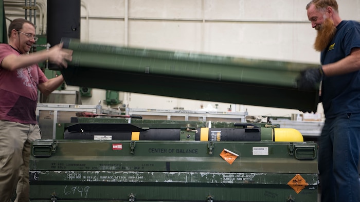 Naval Air Systems Command munitions inspectors Jack Sigler, left, and Greg Groover unseal an AGM-114 HELLFIRE missile from a storage container Feb. 5, 2019, at the Naval Weapons Station in Goose Creek, S.C.