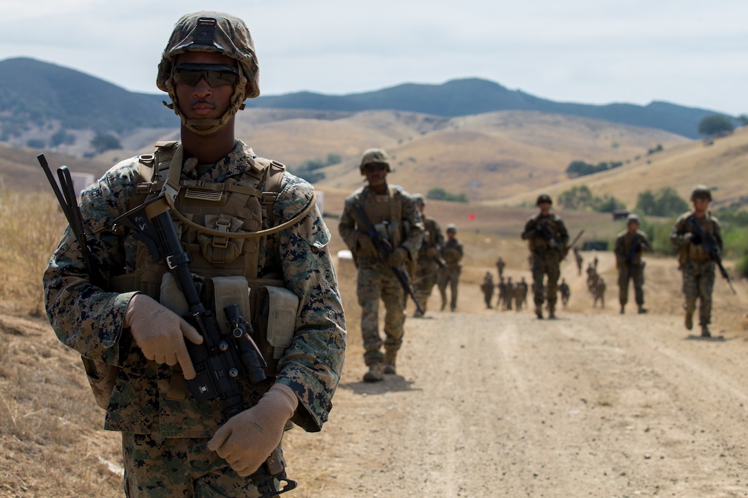 U.S. Marine Corps Sgt. Christopher Johnson, left, a field radio operator with 9th Communication Battalion, Task Force Koa Moana (TF KM) patrols with a squad during the TF KM Mission Rehearsal Exercise at Marine Corps Base Camp Pendleton, Calif., July 18, 2018. The exercise prepared the task force for its upcoming deployment by increasing its capability and readiness to execute theater security cooperation events. (U.S. Marine Corps photo by Lance Cpl. Clare J. McIntire)