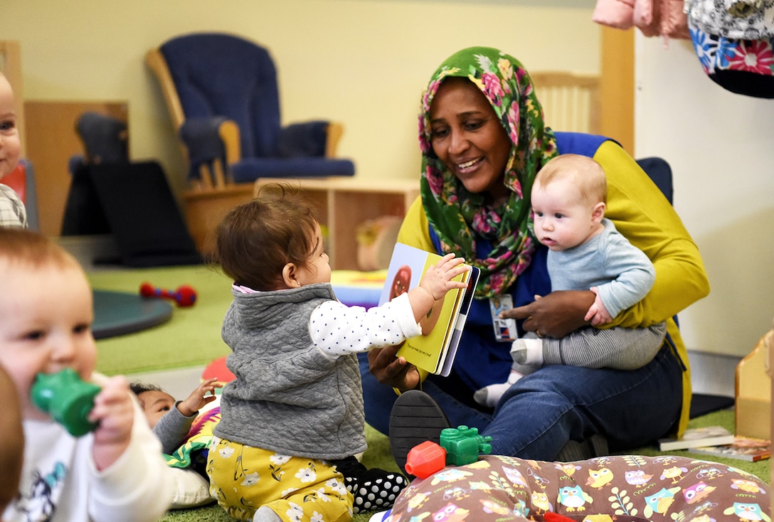 Emtithal Sulieman reads a book with colorful illustrations to help develop babies’ voice and image-recognition skills at DLA’s Fort Belvoir, Virginia, Child Development Center.