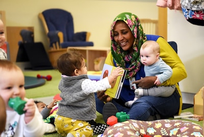 Emtithal Sulieman reads a book with colorful illustrations to help develop babies’ voice and image-recognition skills at DLA’s Fort Belvoir, Virginia, Child Development Center.